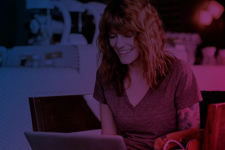 lächelnde Frau vor Laptop sitzend