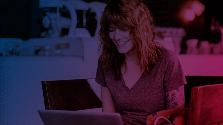lächelnde Frau vor Laptop sitzend